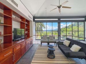 a living room with a couch and a tv at Casa Cielo Luxury Jungle Retreat, Manuel Antonio in Quepos