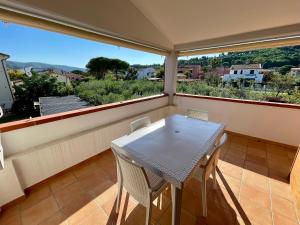 een witte tafel en stoelen op een balkon met uitzicht bij Appartamenti Marisol in Marina di Campo