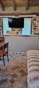 Una sala de estar con un sofá, una mesa y un televisor. en Haraneko errota, en Chávarri