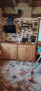 una cocina con armarios de madera y una pared de piedra. en Haraneko errota, en Chávarri