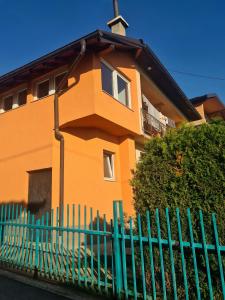 a orange building with a blue fence in front of it at Vila AT in Sarajevo