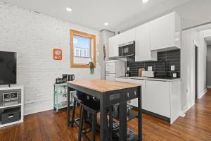 a kitchen with white cabinets and a wooden table at Downtown Denver Suite - Skyline Views in Denver +27 photos