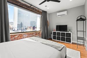 a bedroom with a bed and a large window at Downtown Denver Suite - Skyline Views in Denver