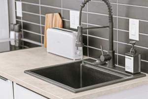 a kitchen counter with a sink and a toaster at Downtown Denver Suite - Skyline Views in Denver