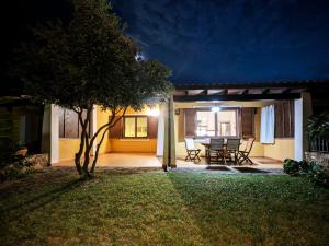 a patio at night with a table and chairs at Villa Sa Perla - Pool, Panoramic View, 250m to Seafront, 650m to Beach in Marina di Gairo +32 photos