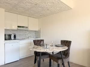 ein Esszimmer mit Tisch und Stühlen und eine Küche in der Unterkunft White dream in Gréolières les Neiges