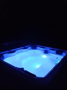 a hot tub with a blue light in the dark at Durbuy Chalet 9p jacuzzi billard jeux in Durbuy