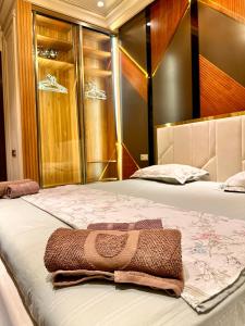 a bedroom with two beds with a towel on it at BOULEVARD NEST RESlDENCE in Tashkent
