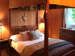 een slaapkamer met een hemelbed met witte lakens en kussens bij Wattles-E4527 in Uplowman