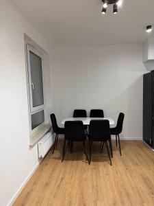 a table and chairs in a white room with a window at Mieszkanie 3 pokojowe Marki in Marki