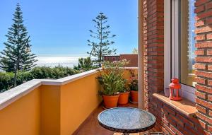 a balcony with a table and potted plants at Lovely Home In Almuñecar With Ethernet Internet in Almuñécar +23 photos
