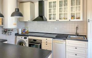 a kitchen with white cabinets and a black counter top at Lovely Home In Almuñecar With Ethernet Internet in Almuñécar