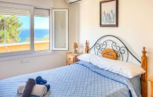 a bedroom with a bed with a blue teddy bear on it at Lovely Home In Almuñecar With Ethernet Internet in Almuñécar