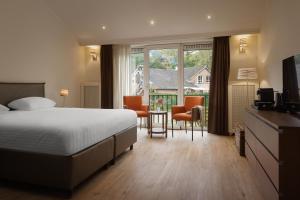 a hotel room with a bed and a table and chairs at Hotel Duinrand Drunen in Drunen