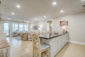 eine Küche mit Theke mit Stühlen und ein Wohnzimmer in der Unterkunft Blessings by the Sea in Port Bolivar