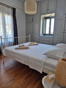 a bedroom with a white bed with two towels on it at Kampi Apartment in Chora Folegandros