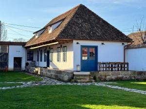 une petite maison blanche avec une porte bleue dans l'établissement Gabri Guesthouse Transylvania, 