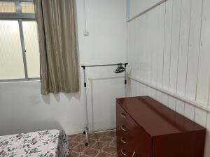 ein Schlafzimmer mit einer Kommode, einem Fenster und einer Kommode in der Unterkunft Casa perto da Expointer in Esteio