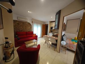 a living room with a red couch and a bedroom at Apartamento Cambral in Lumpiaque