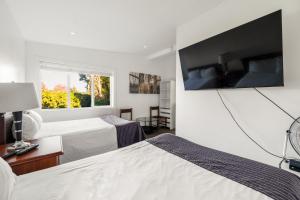a hotel room with two beds and a flat screen tv at Grantview Inn in Surrey
