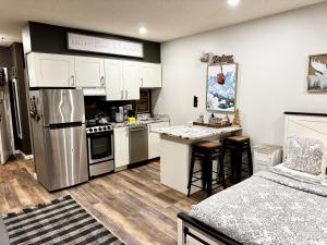eine Küche mit weißen Schränken und einem Edelstahlkühlschrank in der Unterkunft B103 Stylish Loon Mountain Studio Condo with Pool and Hot Tub in Lincoln