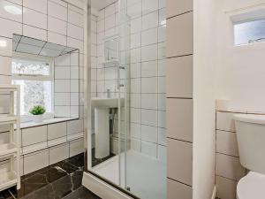 a white bathroom with a shower and a mirror at 3 Bed in Machynlleth 93083 in Cemmaes