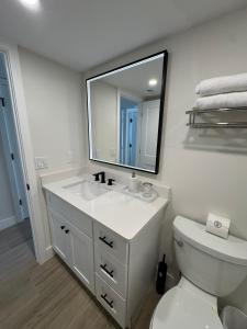 un bagno con lavandino, WC e specchio di Irresistible Beach Life, Spectacular Sunsets - FMB - Condo Sunset Vista - Roelens a Fort Myers Beach Altre 22 foto