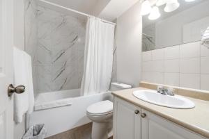 a white bathroom with a sink and a toilet at Grantview Inn in Surrey +20 photos
