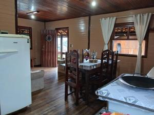 a kitchen with a table and chairs and a refrigerator at Casas particulares Heil e Abadir in Urubici