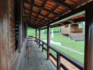 a porch of a log cabin with a wooden roof at Casas particulares Heil e Abadir in Urubici