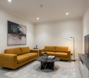 een woonkamer met twee gele banken en een salontafel bij Gevrek Apart izmir in Karşıyaka
