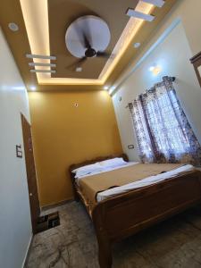 a bedroom with a bed with a ceiling fan at Shri Durga Paradise in Tumkūr