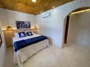a bedroom with a bed in a white room at Villa da Praia -Orla de Atalaia in Aracaju