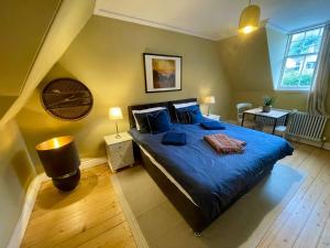 a bedroom with a large blue bed with blue pillows at Room 2, Wedale House in Stow