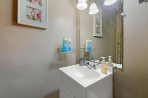 a white bathroom with a sink and a mirror at Next Stop! Comfort! 3 BR Near Amtrak Station! in Richmond +42 photos