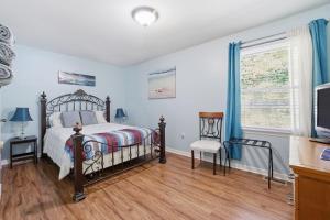 a bedroom with a bed and a tv and a window at Next Stop! Comfort! 3 BR Near Amtrak Station! in Richmond