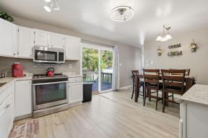 a kitchen with white cabinets and a dining room with a table at Next Stop! Comfort! 3 BR Near Amtrak Station! in Richmond