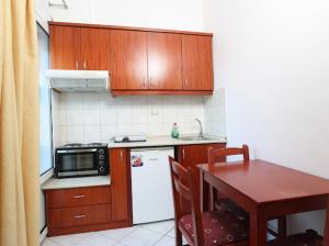 a kitchen with wooden cabinets and a table with a microwave at Villa Anna in Hanioti +8 photos