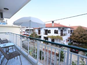 a balcony with an umbrella and a table and chairs at Villa Anna in Hanioti