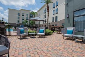 a patio with chairs and tables in front of a building at Homewood Suites by Hilton Houma in Houma