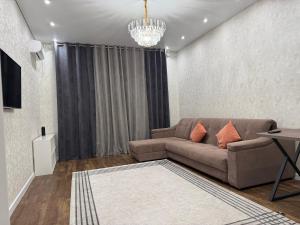 a living room with a couch and a chandelier at Baysanat in Karagandy