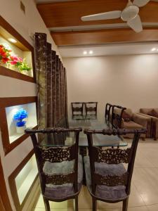 a dining room with a glass table and chairs at The Oak Residence in Islamabad
