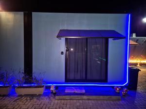 伊瓜苏Casa Container Oceano的建筑物入口处亮着蓝灯,门也在那里。