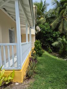 a front porch of a house with palm trees at Kreyol Chic in Le Gosier +13 photos