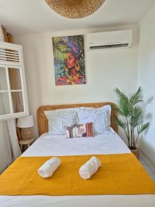 a bedroom with a bed with two pillows on it at Kreyol Chic in Le Gosier