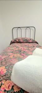 ein Bett mit einer geblümten Bettdecke und zwei Handtüchern. in der Unterkunft big house - vicino 20 minuti da PISA e LUCCA in Buti