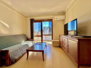 un soggiorno con divano e TV a schermo piatto di Apartamento no centro de Gramado a Gramado