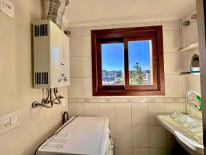 un piccolo bagno con finestra e lavandino di Apartamento no centro de Gramado a Gramado Altre 34 foto