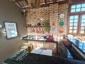a kitchen with a counter and a brick wall at Mar Doce Lar - Praia Macapa in Luis Correia