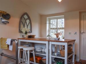 een keuken met een aanrecht met krukken en een raam bij Rowan Cottage in Rosedale Abbey